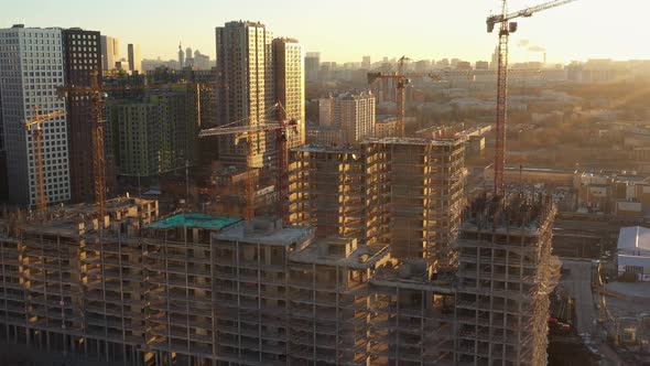 Several Construction Tower Cranes in the Process of Building Houses in a New Residential Complex at