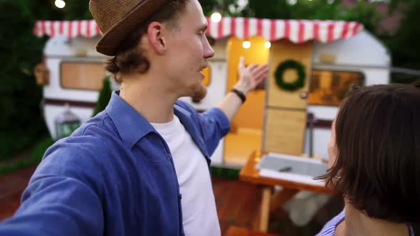 Young Man and Woman Recording Video for Friends Using Smartphone or Camera