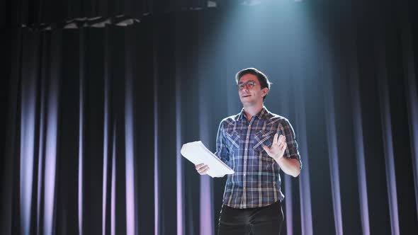 Stand Up Comedian on Stage. Young Man Talks Joke Into Microphone or Sings Songs