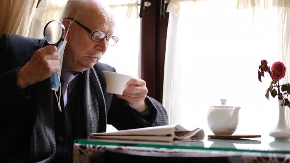 The Old Grandfather Reads the Latest News From the Newspaper at the Table the Pensioner is Resting