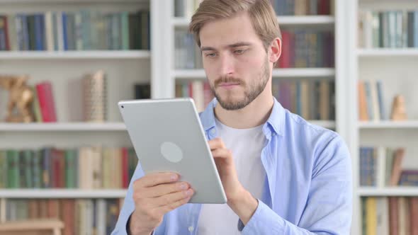 Portrait of Attractive Man Using Tablet in Office