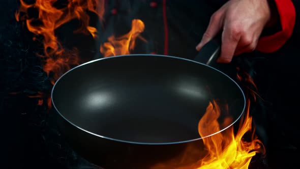 Super Slow Motion Shot of Chef Holding Empty Frying Pan and Flames at 1000Fps.