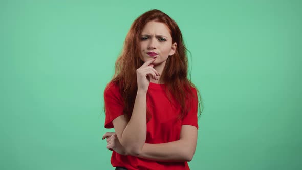 Thinking Woman Looking Up on Green Studio Background