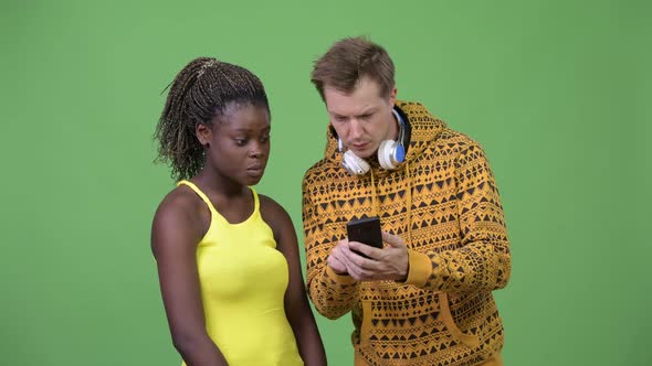 Young Multi-ethnic Couple Using Phone Together