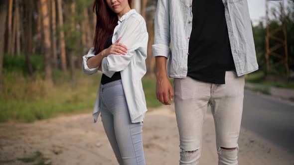 Unrecognizable Couple Hitchhiking Outdoors with Blurred Car Stopping at Background