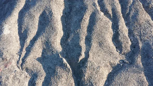 Erosion of bare wrinkled rock - texture of a rough stone with furrowed surface and no vegetation