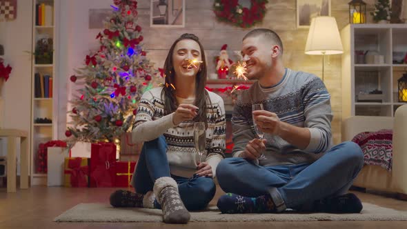 Cheerful Couple on Christmas Day Holding Hand Fireworks