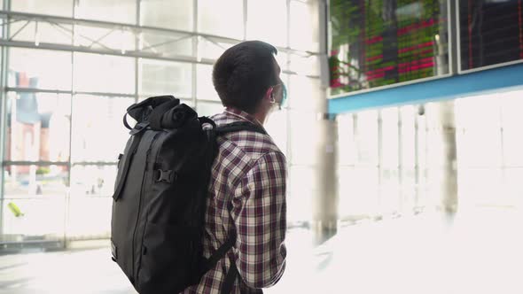 Caucasian Male Traveler in Medical Mask Takes Out Passport and Ticket From Back Pocket of Jeans in