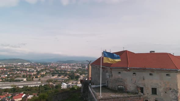 Ukrainian Flag Flies on Wall of an Ancient Medieval Castle in Small European City