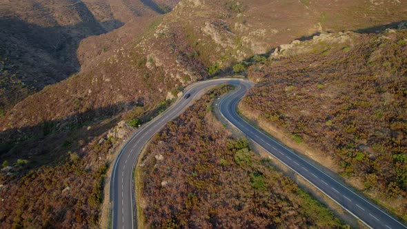 Drone Of Single Car Driving Along Empty Winding Road