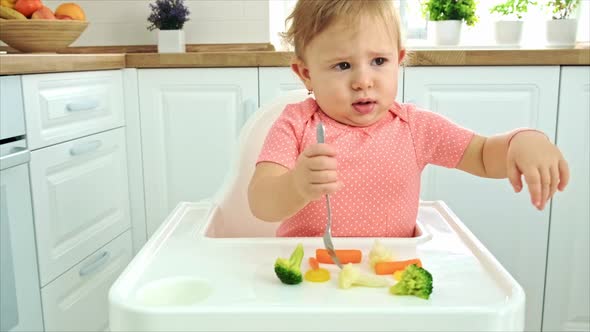 Baby Eats Vegetables on a Chair