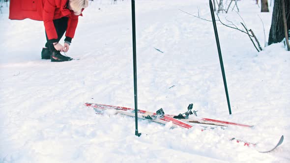 A Woman Prepares To Stand on the Ski - Tie Up Her Shoes