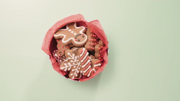 Traditional home made gingerbread cookies as food gifts on blue background with Christmas light.