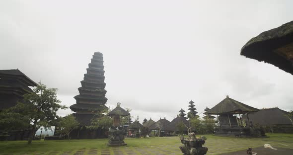 Tilting Dolly Shot of Grassy Temple Grounds with Black Stone Statues Tall Pagodas and Religious