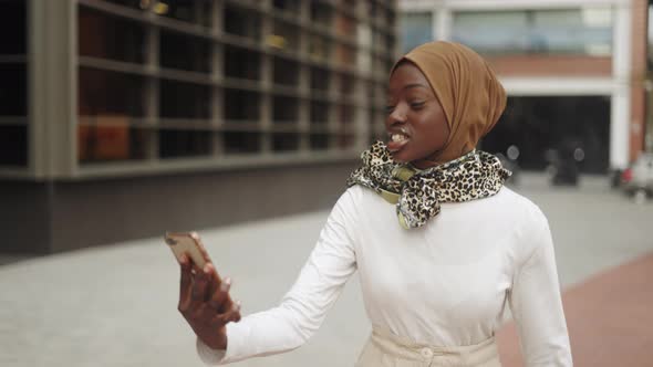 Muslim Woman Making Video Call on Street