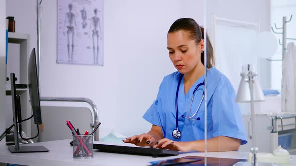 Medical Woman Nurse Typing on Computer Patient Health Report