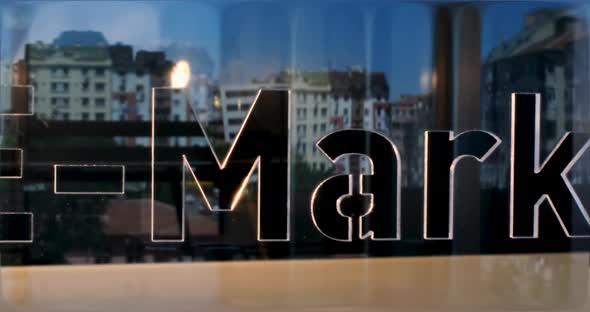 Glass E-Marketing Letters and Office in Background