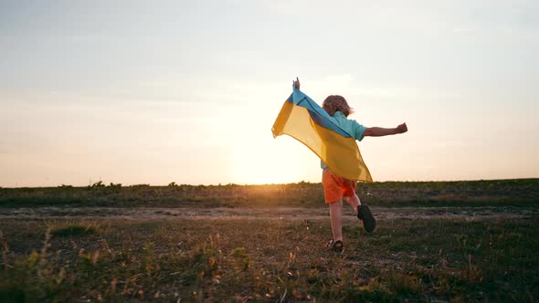 Cute Little Boy  Ukrainian Patriot Kid Running with National Flag on Open Area Field