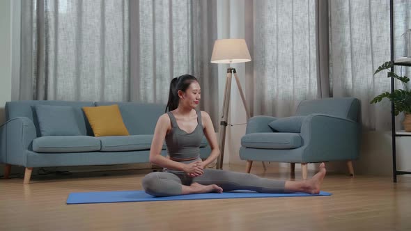 Asian Trainer Female In Sports Clothes Speaking And Doing Hamstring Stretch While Teaching Exercise