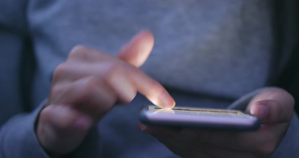 Woman using smart phone in the evening