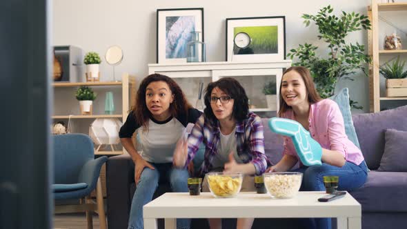 Young Ladies Expressing Positive Emotions After Successful Sports Game on TV