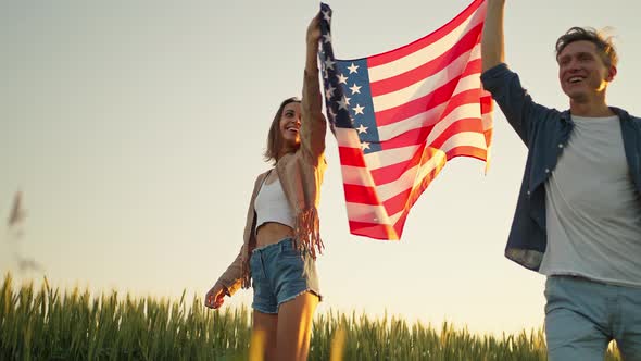 Slow Motion of Happy Patriotic Couple Celebrating Fourth of July with National Flag in Rural