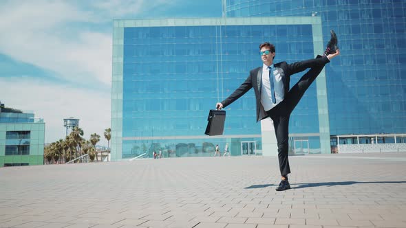 Flexible and cool businessman doing acrobatic tricks outdoor.