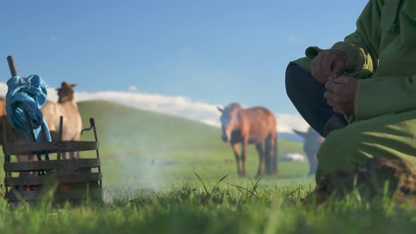 A Man Sitting Warms the Branding Iron