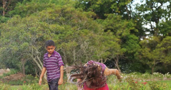 Kids playing with garden sprinkler