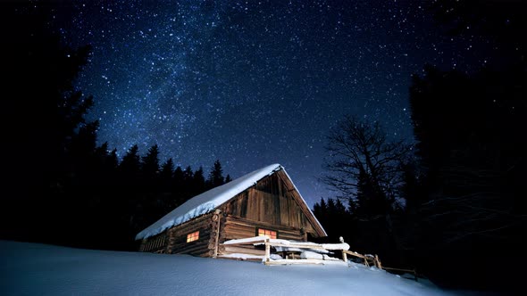 Beautiful wooden house in the winter forest under the twinkling stars. Cinemagraph.