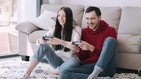 A Pretty Girl and a Boy Are Playing Video Games in the Living Room