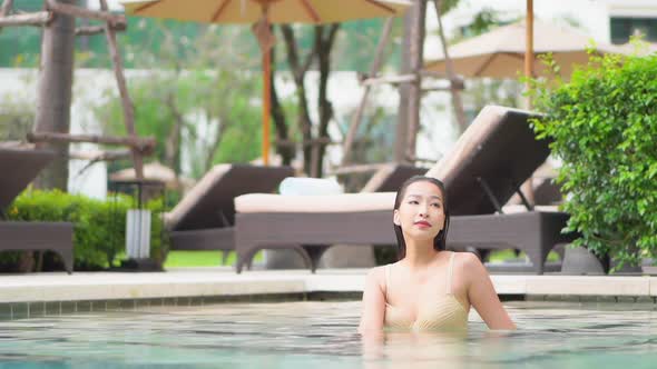 Young asian woman enjoy around outdoor swimming pool for leisure