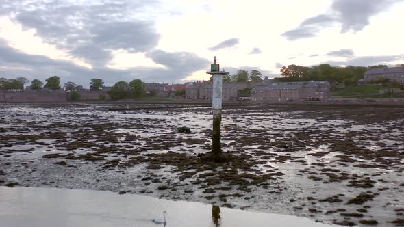 A Channel Marker at Low Tide in an Estuary