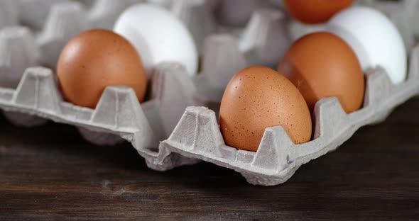 The Men's Hand Puts Raw Eggs on a Paper Stand.