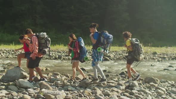 Positive Diverse Multiethnic Hikers with Backpacks Trekking in Mountains