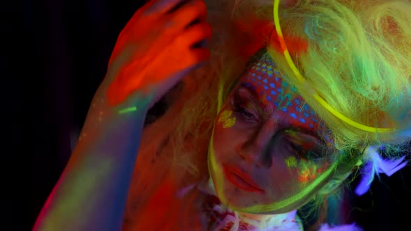 Amazing Beautiful Woman with Fluorescent Makeup on Face and Neon Hair Closeup Portrait