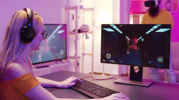 Girl Playing Shooter Games in a Room with Colorful Neon Lights