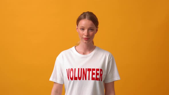 Happy woman volunteer walking and pointing at her t-shirt