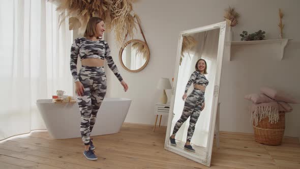 Happy Charming Adult Woman Admiring Perfect Body Shape While Looking at Reflection in Mirror