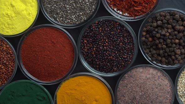 Assortment colorful spices, seeds and herbs for cooking food rotate, top view