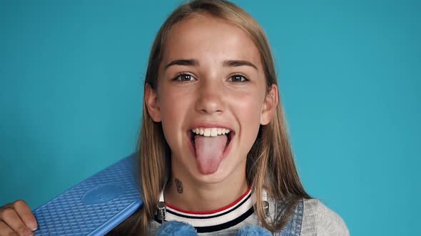 The Teenage Girl Shows a Tongue and Laughs