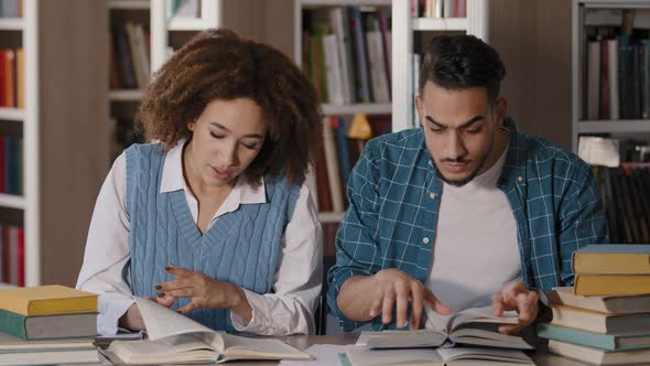 Students Guy and Girl Classmates are Sitting in Library Intently Looking for Necessary Information