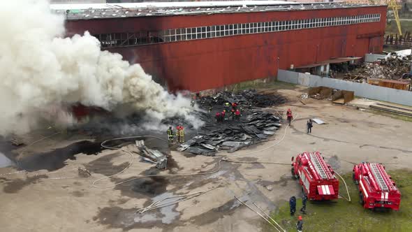 Aerial View of Firemen Fighting with Fire Near Old Factory Biulding in Industrial Area