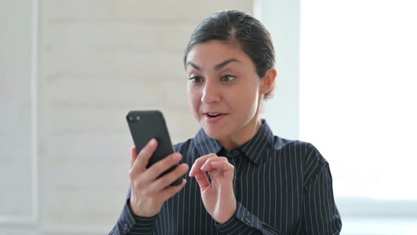 Excited Indian Woman Celebrating Success on Smartphone