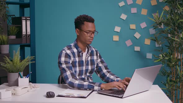 Positive Employee Giving Thumbs Up in Front of Laptop Screen