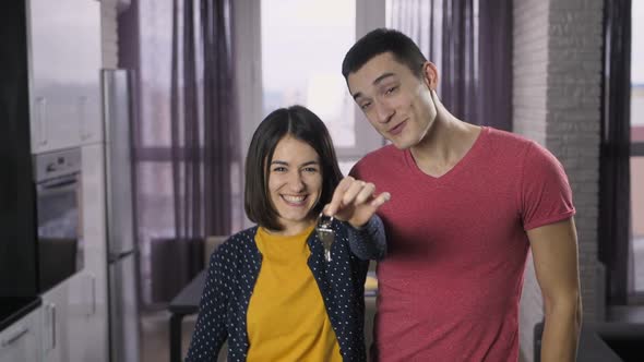 Delighted Couple Shaking Keys and Dancing