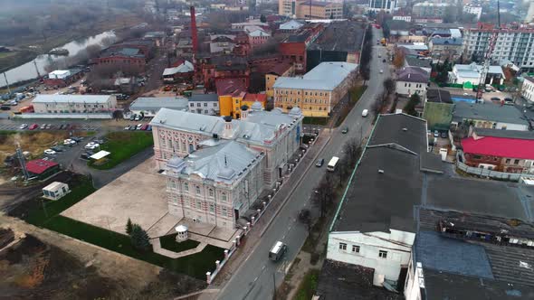 Cars Drive Along Avenue Across Large City on Gloomy Day