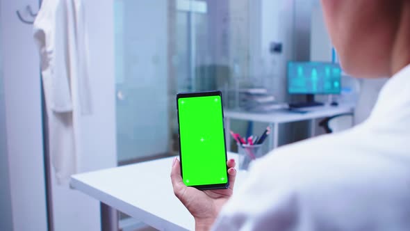 Medical Physician Looking at Phone with Green Screen