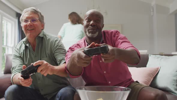 Animation of happy diverse male senior friends playing video games