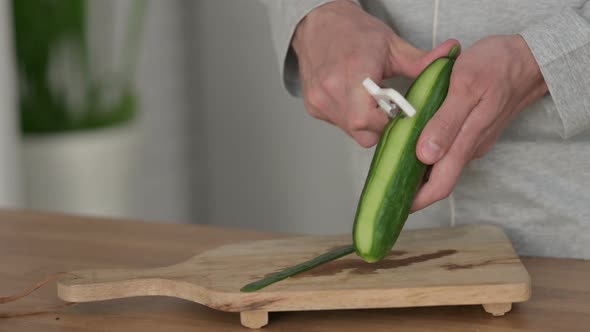 Close Up Shot of Hands of Man Cutting Cucumbers on Cutting Board